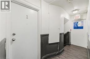 Hamilton apartment for rent - A white door with the number 1 on it is in a room with a white wall and a black door.