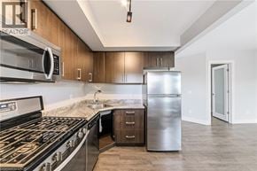 Hamilton apartment for rent - A modern kitchen with a stainless steel refrigerator, microwave, and oven.