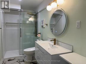 Thorold (Rolling Meadows) apartment for rent - A bathroom with a sink, mirror, and shower.