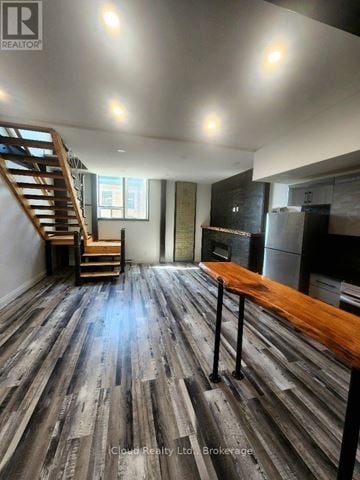 Hamilton (Dundas) multi-family for rent - A room with wooden floors and a staircase.