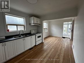 Toronto (Clairlea-Birchmount) apartment for rent - A kitchen with white cabinets and a wooden floor.