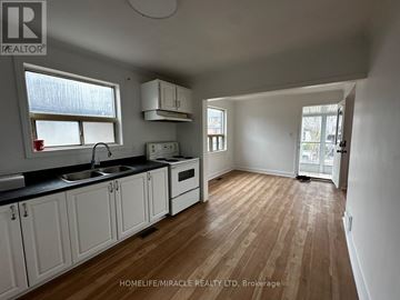 Toronto (Clairlea-Birchmount) apartment for rent - A kitchen with white cabinets and a wooden floor.