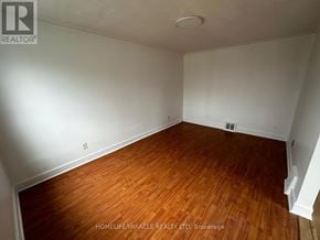 Toronto (Clairlea-Birchmount) apartment for rent - A room with wooden flooring and white walls.