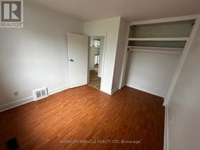Toronto (Clairlea-Birchmount) apartment for rent - A room with wooden flooring and white walls, with a doorway leading to another room.