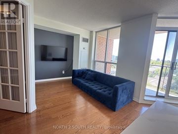 Mississauga (Lakeview) condo for rent - A living room with a blue couch and a flat screen TV.