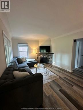 Windsor apartment for rent - A living room with a black couch and a fireplace.