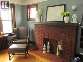 Windsor apartment for rent - A living room with a brown leather chair and a red brick fireplace.