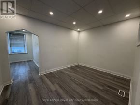 Guelph (Downtown) multi-family for rent - A room with wooden flooring and a window.