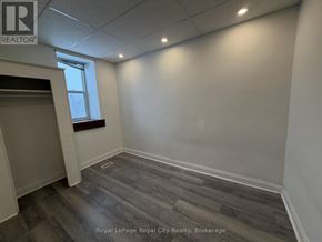 Guelph (Downtown) multi-family for rent - A room with wooden flooring and a window.