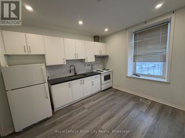 Guelph (Downtown) multi-family for rent - A kitchen with white cabinets and a window.