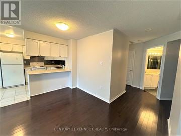 Toronto (Bay Street Corridor) condo for rent - A kitchen with white cabinets and a refrigerator.