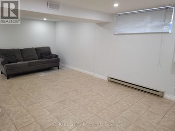 Newmarket (Huron Heights-Leslie Valley) apartment for rent - A living room with a couch and a window with blinds.