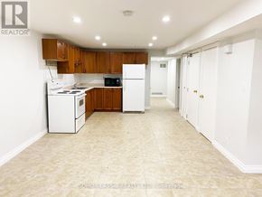 Newmarket (Huron Heights-Leslie Valley) apartment for rent - A kitchen with white appliances and wooden cabinets.