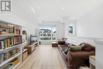 Brant (Paris) townhouse for rent - A living room with a brown leather couch and a bookshelf filled with books.