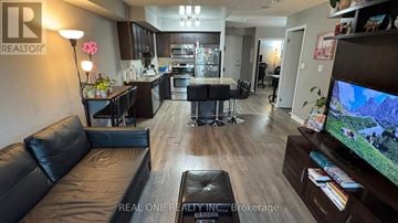 Toronto (Dovercourt-Wallace Emerson-Junction) condo for rent - A living room with a black leather couch and a television.