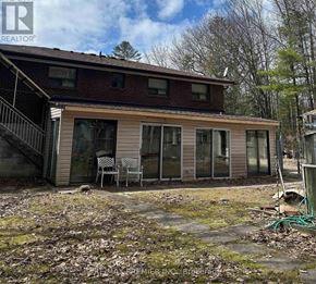Wasaga Beach apartment for rent - A house with a red roof and a porch with chairs.