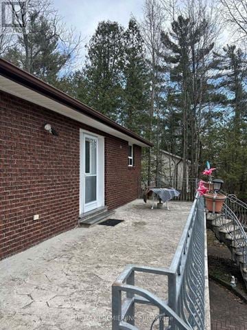 Wasaga Beach apartment for rent - A red brick house with a grey fence and a white door.