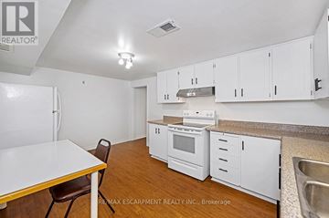 Toronto (Rustic) apartment for rent - A kitchen with white cabinets and a wooden table.