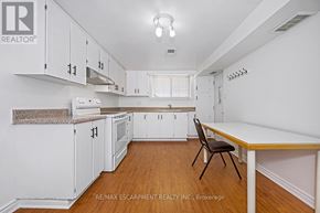 Toronto (Rustic) apartment for rent - A kitchen with white cabinets and a wooden table.