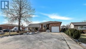 Hamilton (Eleanor) apartment for rent - A real estate photo of a house with a garage and a tree in the front yard.