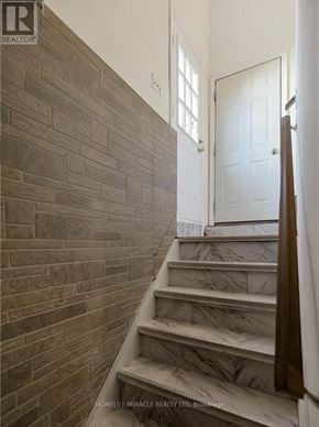 Hamilton (Eleanor) apartment for rent - A staircase with a brown tiled wall and white steps.