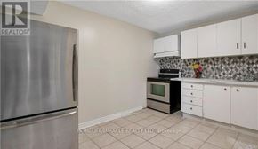 Hamilton (Eleanor) apartment for rent - A kitchen with a stainless steel refrigerator and white cabinets.