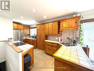 Oakville (Go Glenorchy) apartment for rent - A kitchen with wooden cabinets and a tile backsplash.