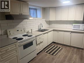 Hamilton apartment for rent - A kitchen with white cabinets and a white stove top oven.