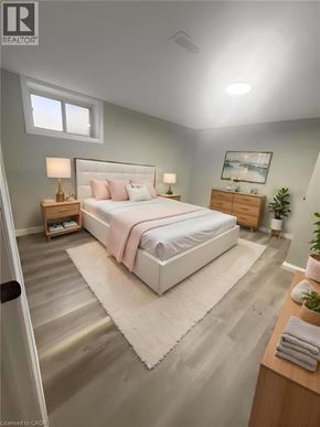 Hamilton apartment for rent - A bedroom with a large bed, a nightstand, and a small plant.
