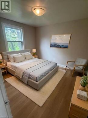 Hamilton apartment for rent - A bedroom with a bed, chair, and painting on the wall.