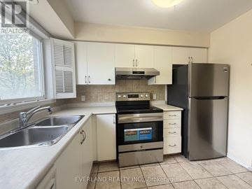 Markham (Milliken Mills East) townhouse for rent - A kitchen with white cabinets and a stainless steel refrigerator.