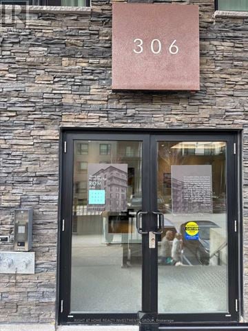 Barrie (400 West) condo for rent - The door of a building with a glass window and a sign that says "306" above it.