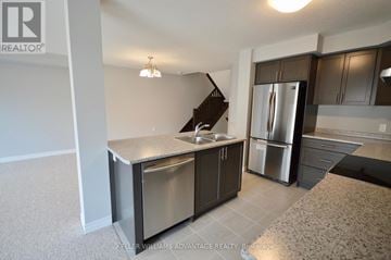 Hamilton (Hannon) townhouse for rent - A kitchen with a stainless steel refrigerator and a sink.