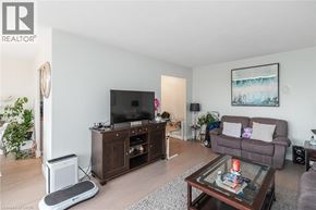 Hamilton apartment for rent - A living room with a brown couch, a television, and a glass coffee table.