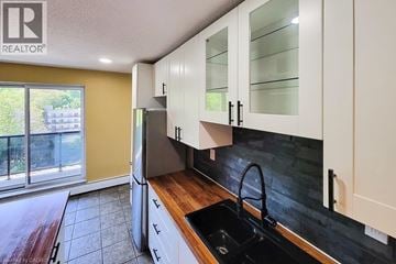 Hamilton condo for rent - A kitchen with white cabinets and a black sink.