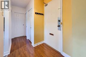 Hamilton condo for rent - A hallway with a white door on the left and a yellow door on the right.