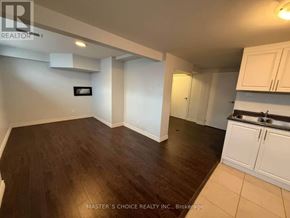 Richmond Hill (Crosby) apartment for rent - A room with wooden flooring and white walls, with a kitchen area to the right.