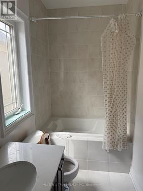 Vaughan (Patterson) apartment for rent - A white bathroom with a shower curtain hanging on a rod.