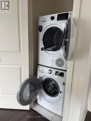 Toronto (Willowdale West) condo for rent - A white washing machine is in a small space next to a door.