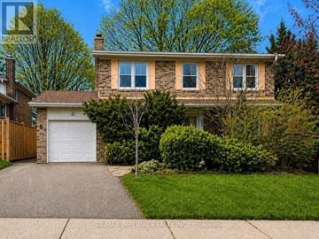 Toronto (Hillcrest Village) apartment for rent - A house with a garage and a tree in front.