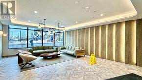 Toronto (Banbury-Don Mills) condo for rent - A living room with a couch, chair, and a table with a yellow sign on it.