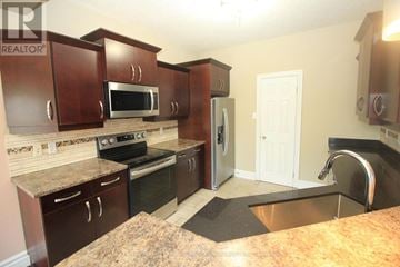 London North (North E) apartment for rent - A kitchen with brown cabinets and a granite counter top.