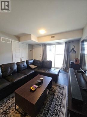 Kitchener townhouse for rent - A living room with a black leather couch and a coffee table.