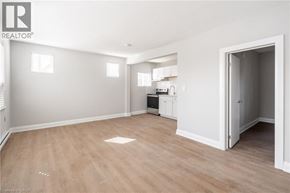 Hamilton apartment for rent - A spacious room with light wood flooring and white walls.