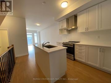 Markham (Cornell) townhouse for rent - A kitchen with white cabinets and a black railing.