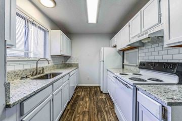 Gainesville apartment for rent - A kitchen with white cabinets and a granite countertop.