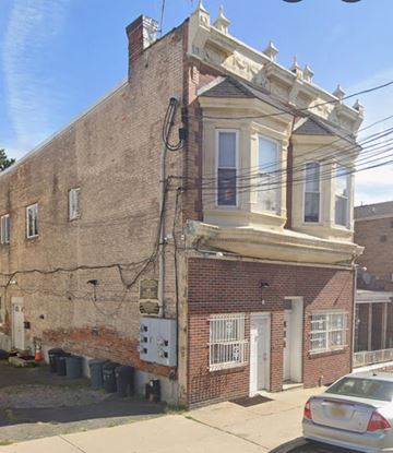 Guttenberg apartment for rent - A car is parked on the sidewalk in front of a brick building.