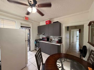 Miami apartment for rent - A kitchen with a white refrigerator and a ceiling fan.