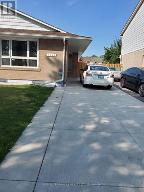 Mississauga (Malton) apartment for rent - A white car is parked in front of a house with the text "HOMELIFE MIRACLE REALTY LTD Brokerage" on the bottom.
