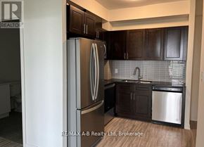 Waterloo condo for rent - A kitchen with a stainless steel refrigerator and dark brown cabinets.